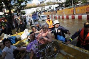 A disabled person is evacuated after floods advanced into her neighborhood in central Bangkok, Oct. 25, 2011. REUTERS/Damir Sagolj