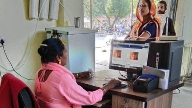 Trained and empowered woman with a disability working with a computer at an OPD-run community 'Indira' kitchen, a scheme of government