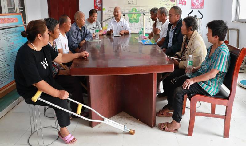 Self-help group of persons with disabilities, their family members and community leaders having a meeting